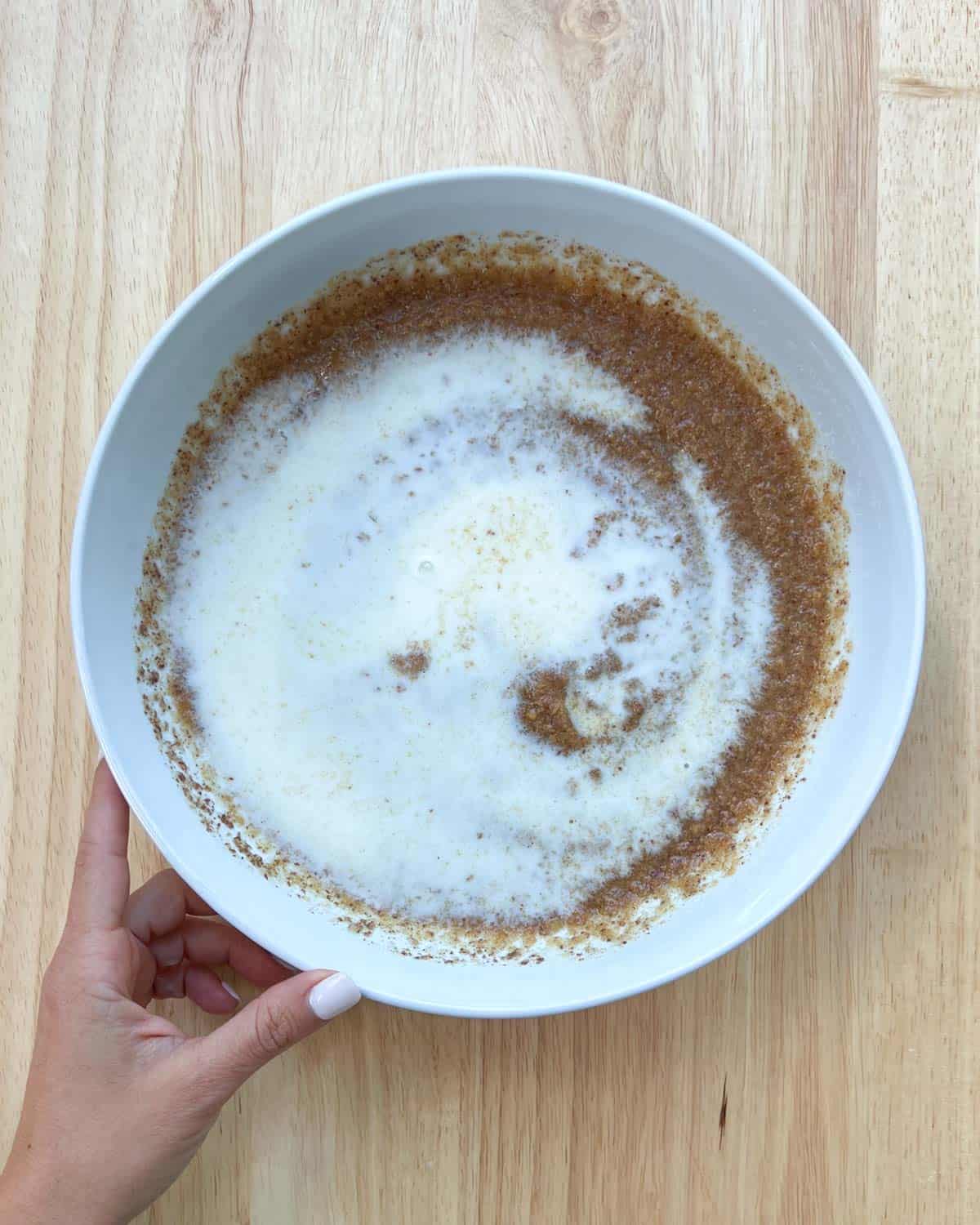 milk added over the peanut butter mixture ina white bowl.