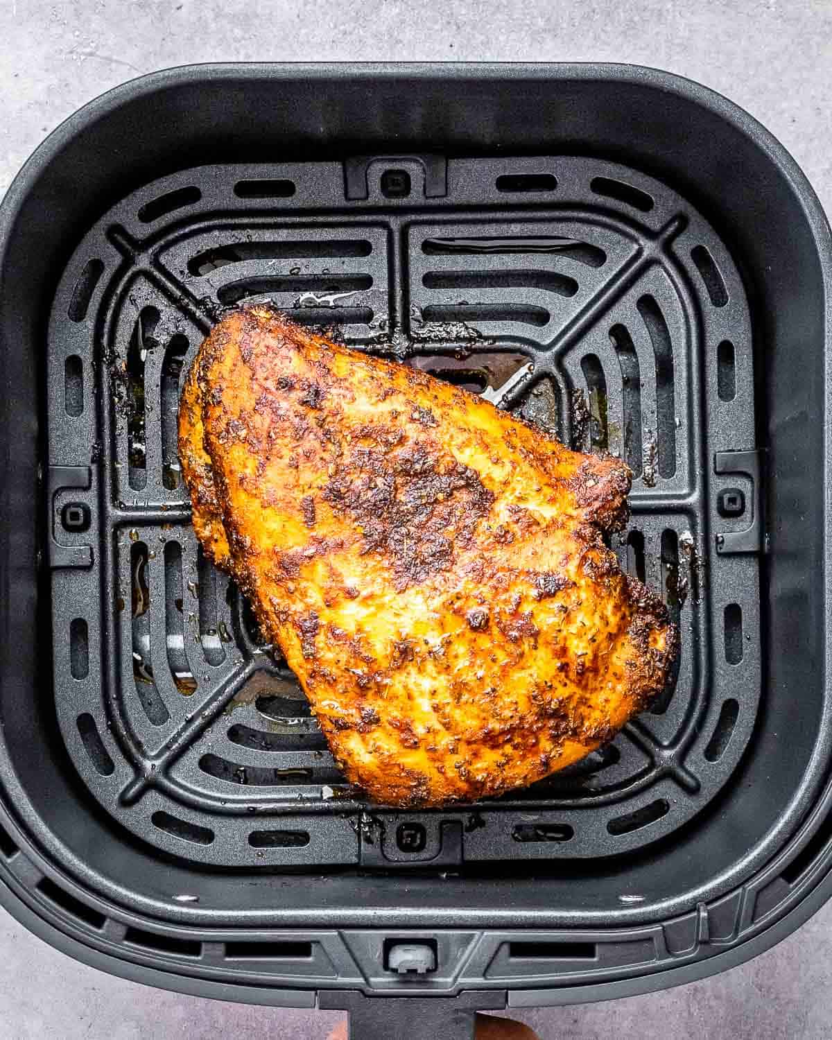 turkey breast air fried in the air fryer basket.