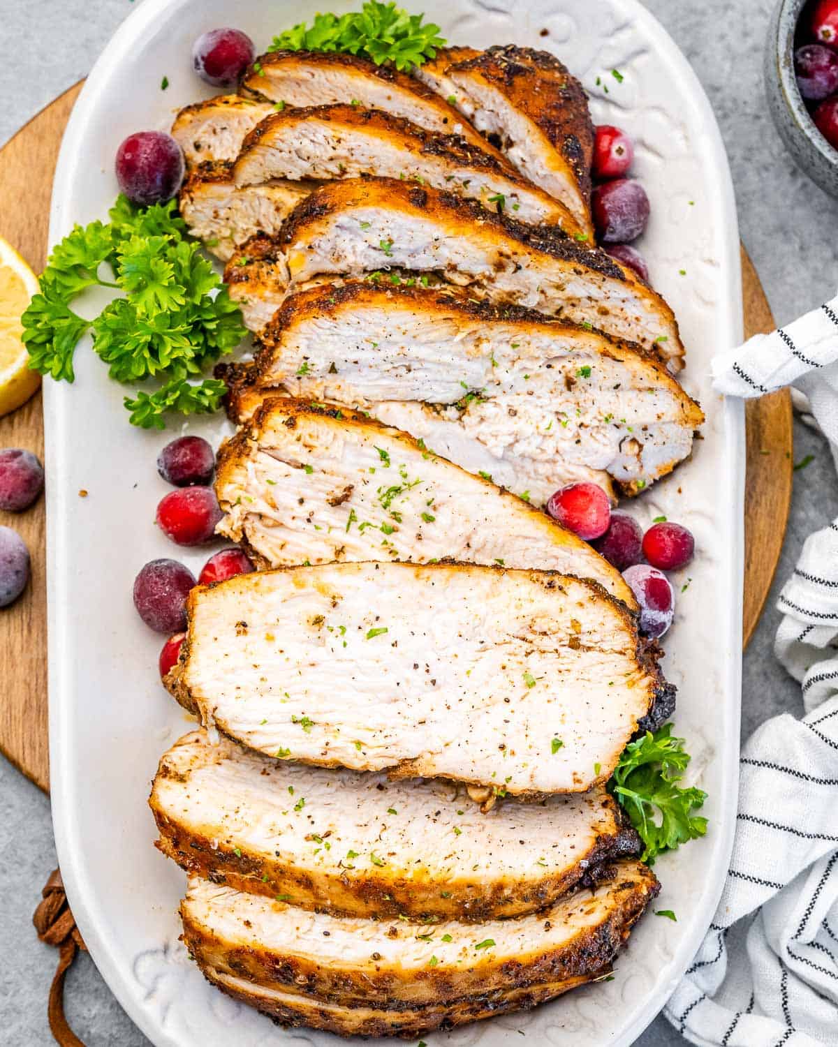 sliced turkey breast phone on a white platter.