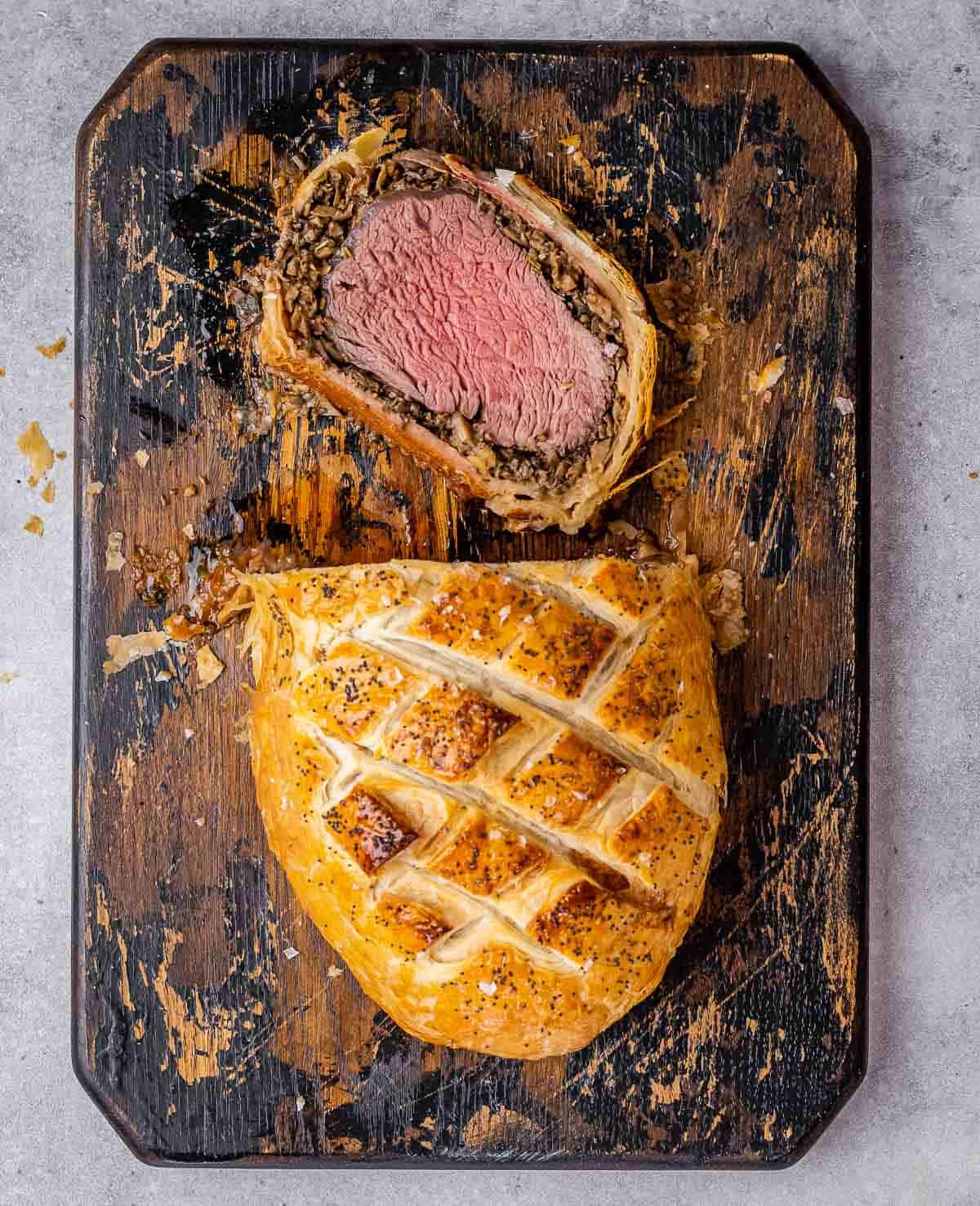 Slice Beef Wellington on a cutting board.