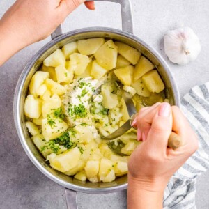Mashing potatoes with a potato masher.