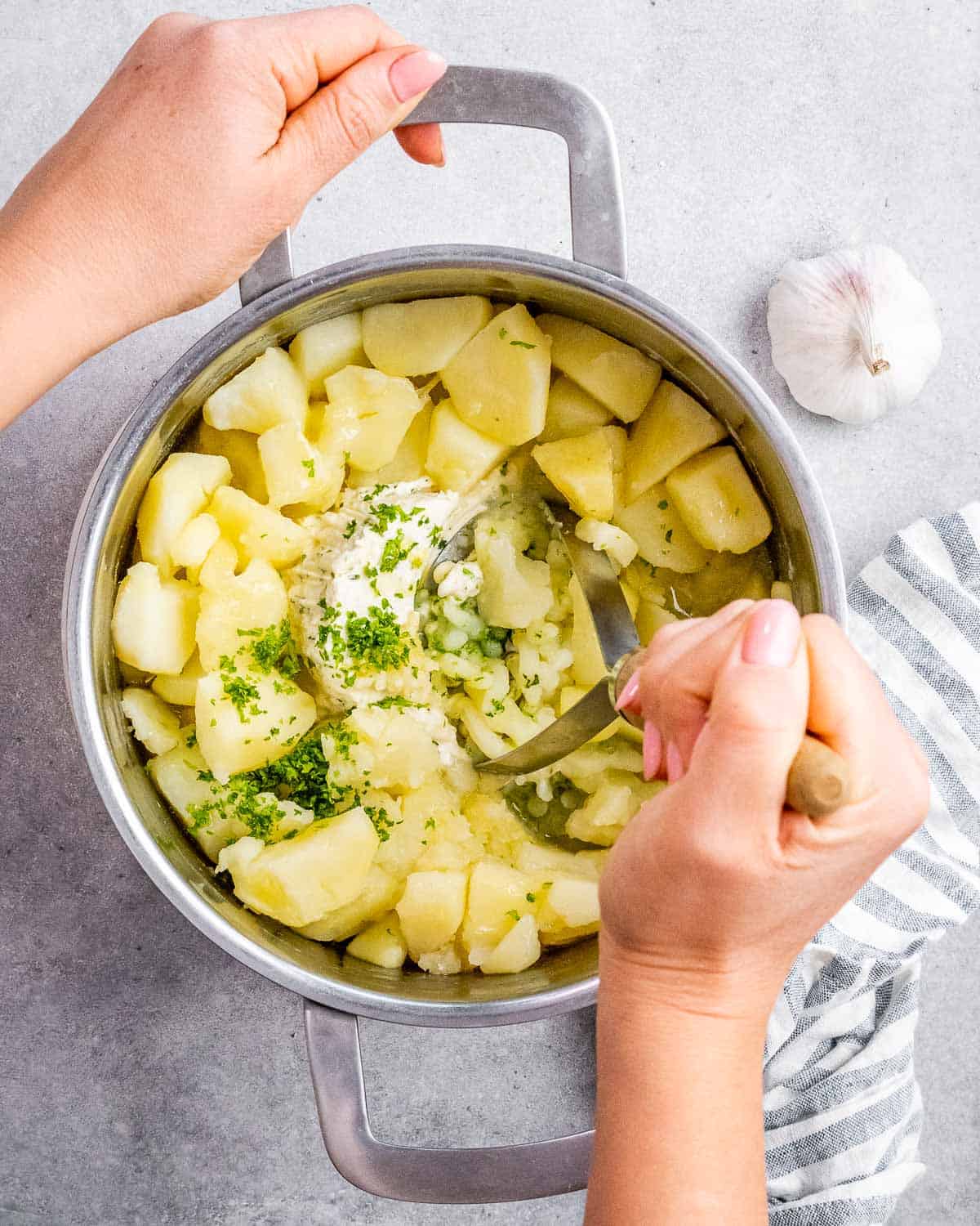 Mashing potatoes with a potato masher.