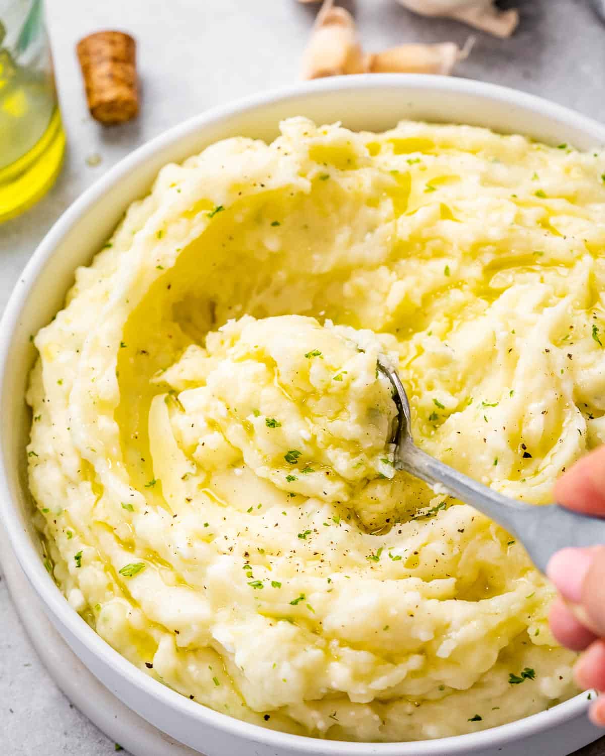 Stirring Boursin mashed potatoes with a spoon.