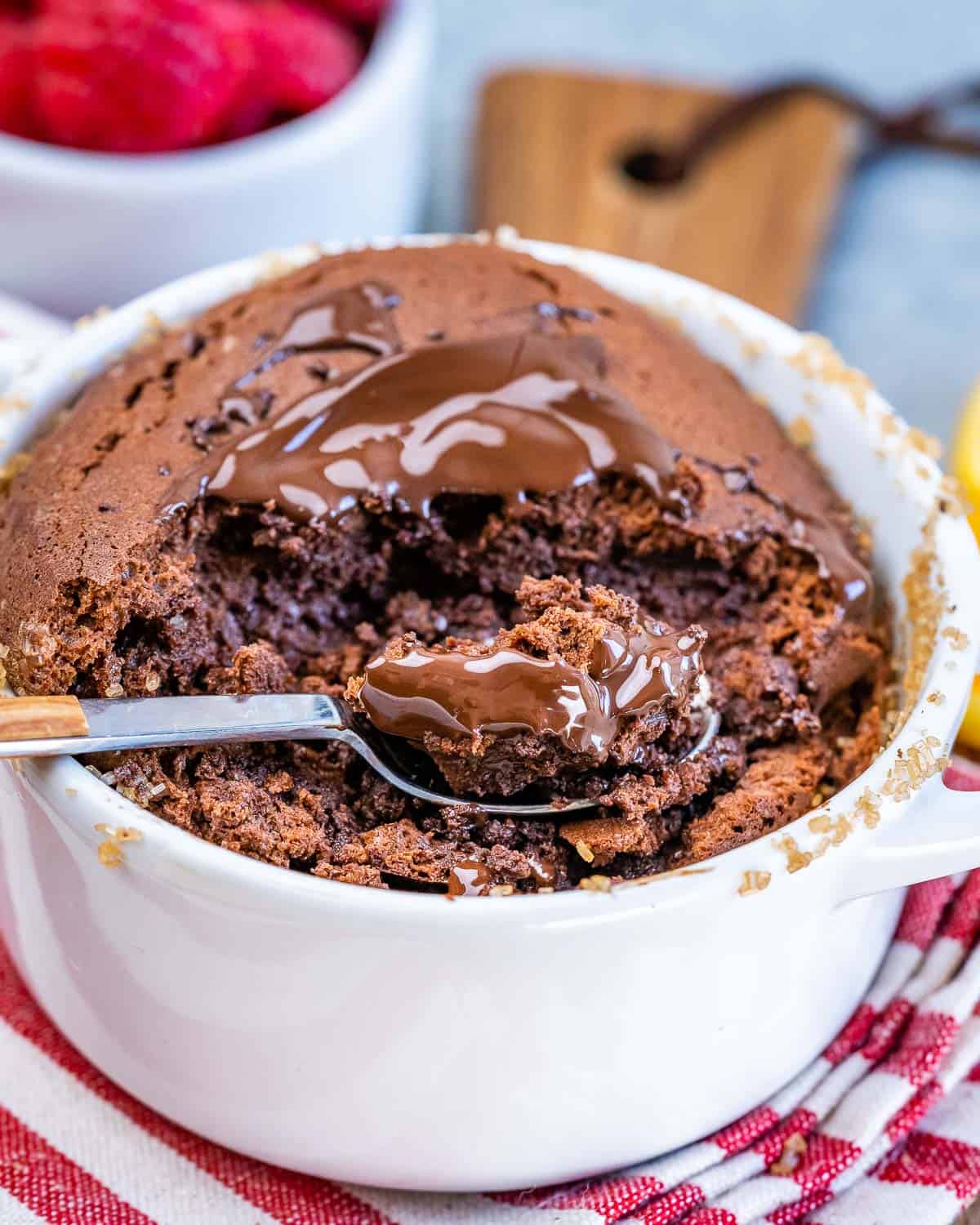 Close-up of a spoonful of warm Chocolate Soufflé showing the rich, mousse-like center and melted chocolate on top.
