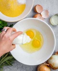 Pouring buttermilk into bowl with eggs.