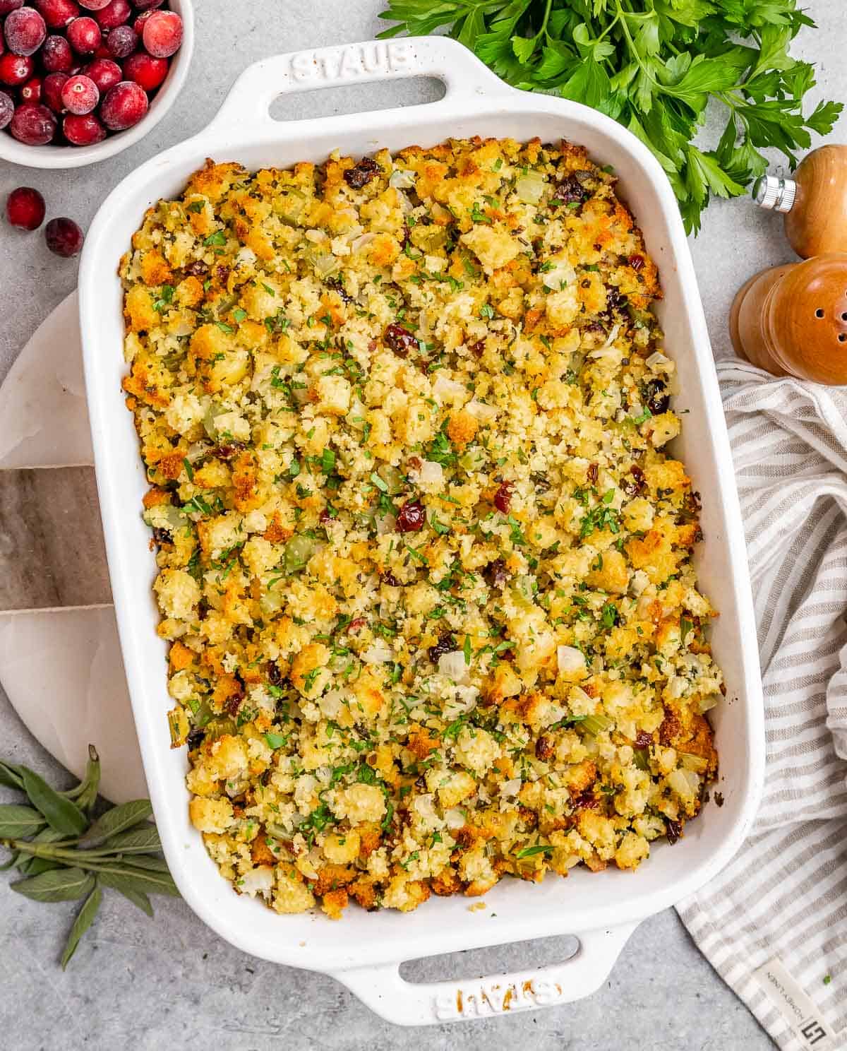 Baked cornbread stuffing in a white casserole dish.