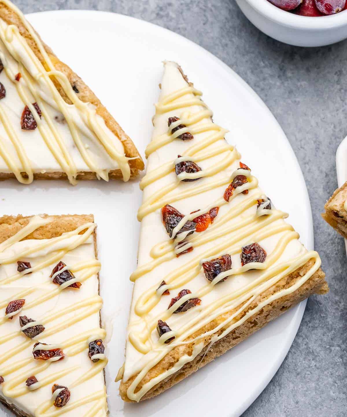 3 slices of cranberry bliss bars on a plate.