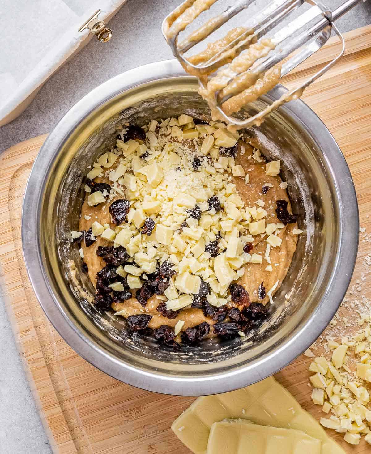 cranberries and chopped chocolate added into the batter in a bowl.