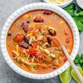 a white bowl of chili with spoon in the bowl.