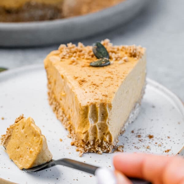 a bite taken off from a slice of pumpkin cheesecake.