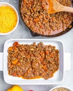 assembling stuffed pepper casserole beef mixture into white baking dish
