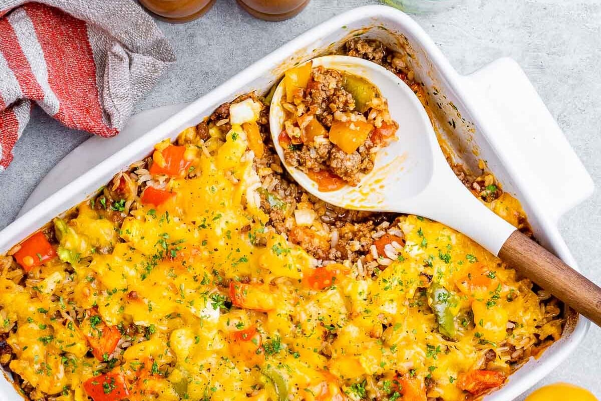 top view of stuffed pepper casserole in white baking dish with spoon