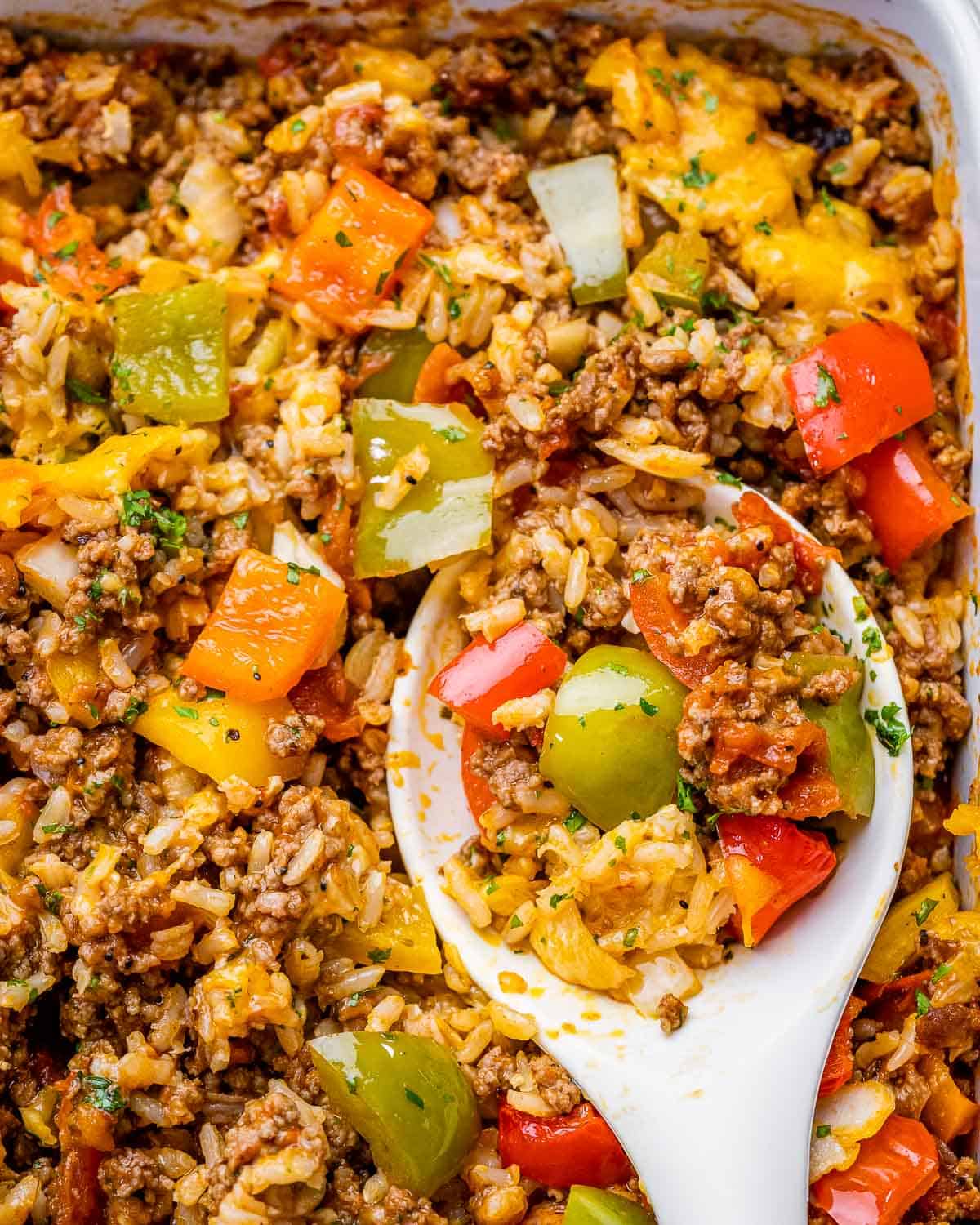 top view image of stuffed pepper casserole in rectangular dish with white spoon
