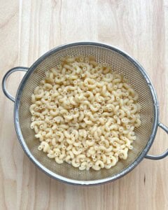 pasta in a colander for butternut squash mac and cheese.