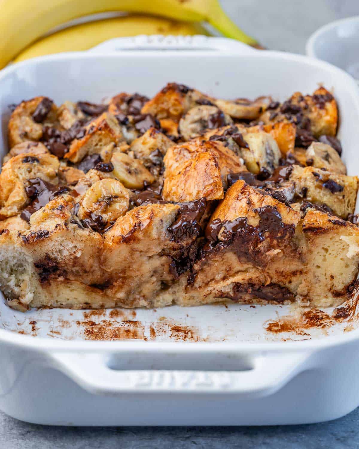 a baking dish with only half of the banana bread pudding in dish.