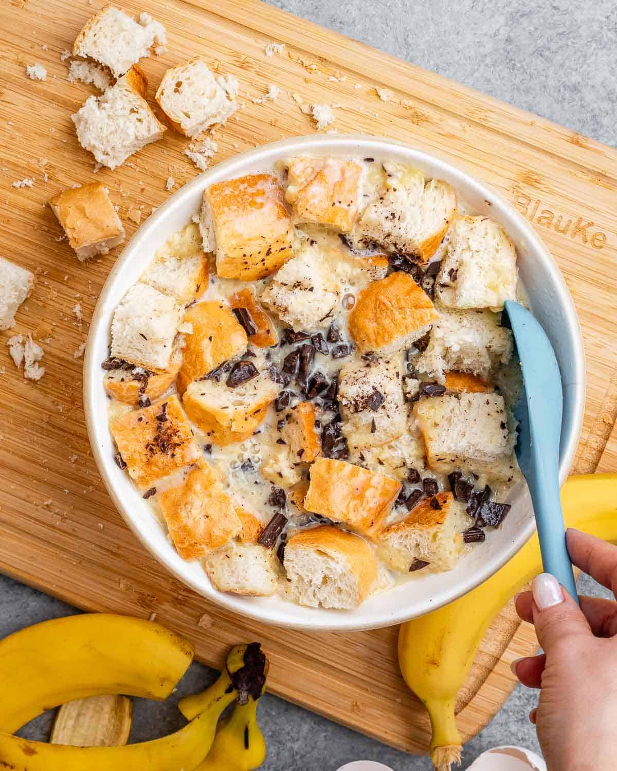 chopped bread added over the egg mixture in a bowl.