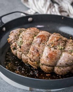 Beef roast being seared in a hot skillet to lock in flavor before baking.