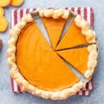 Sweet potato pie with several clean slices cut, showing the creamy orange filling and flaky crust.