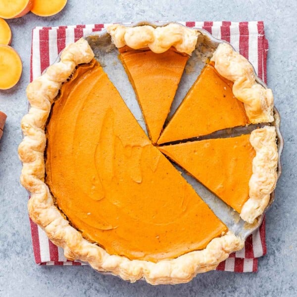 Sweet potato pie with several clean slices cut, showing the creamy orange filling and flaky crust.