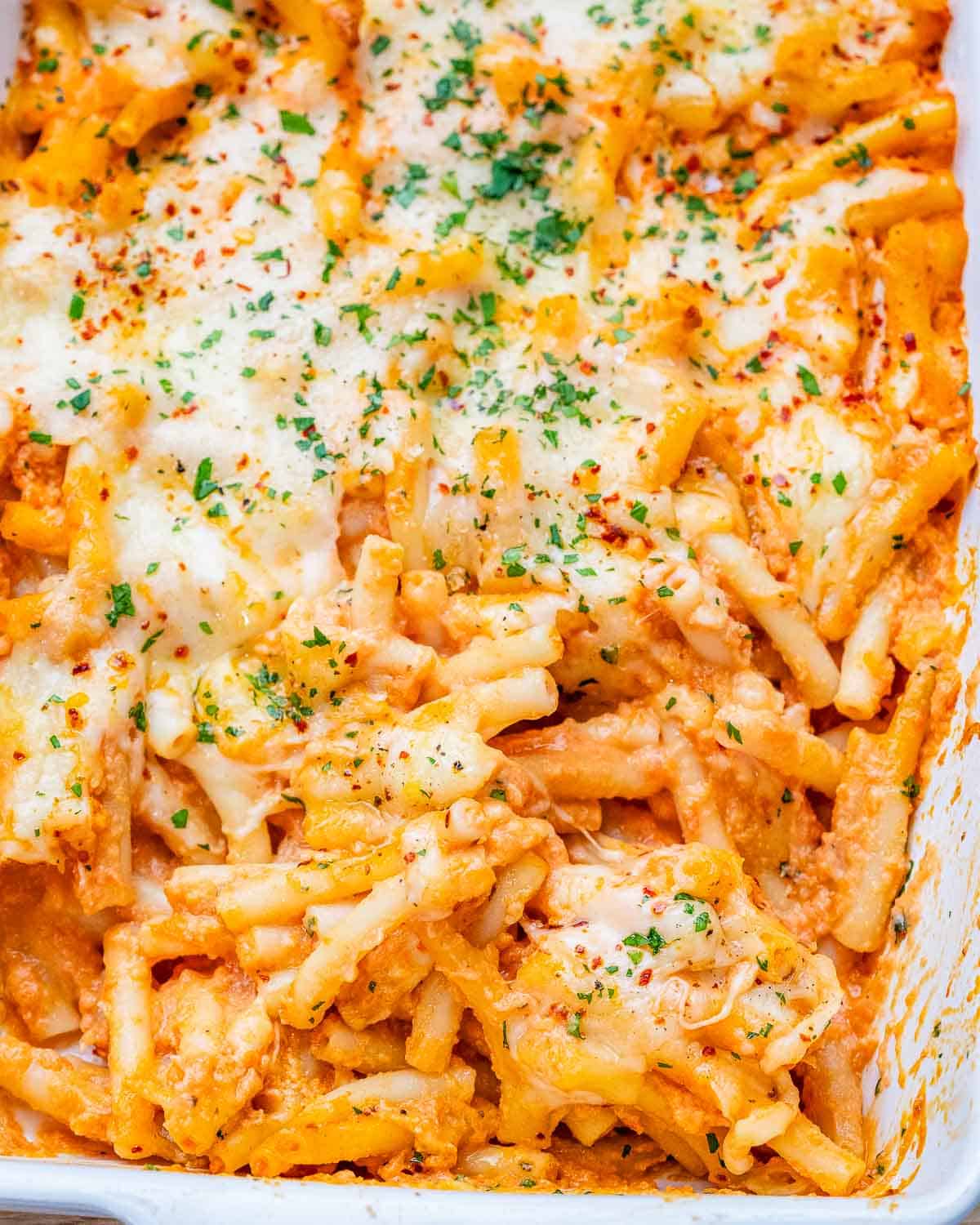 Cheesy tomato pasta in a white casserole dish.