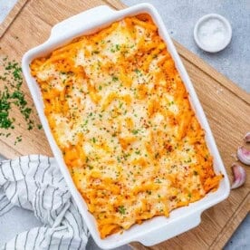 Baked pasta in a white baking dish topped with melted cheese.