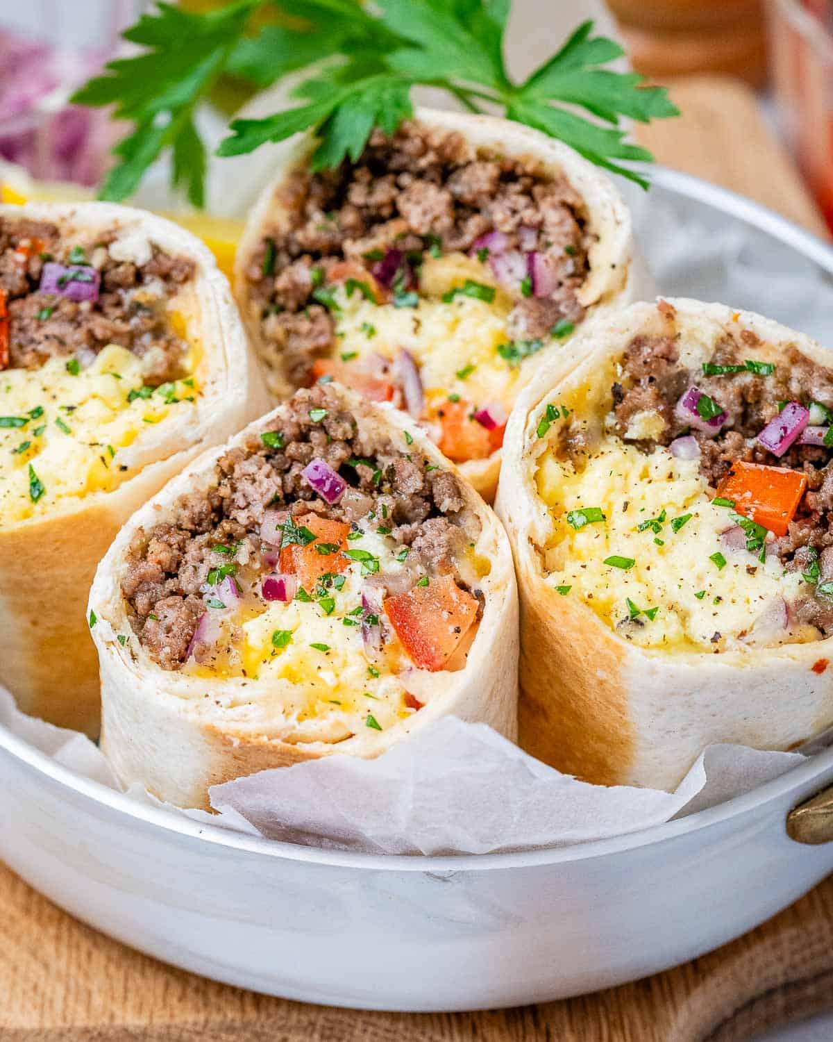 4 burritos cut in half facing up on a plate.