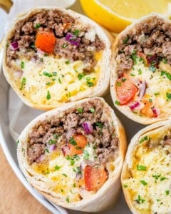 burritos sliced in half facing upwards on a plate.