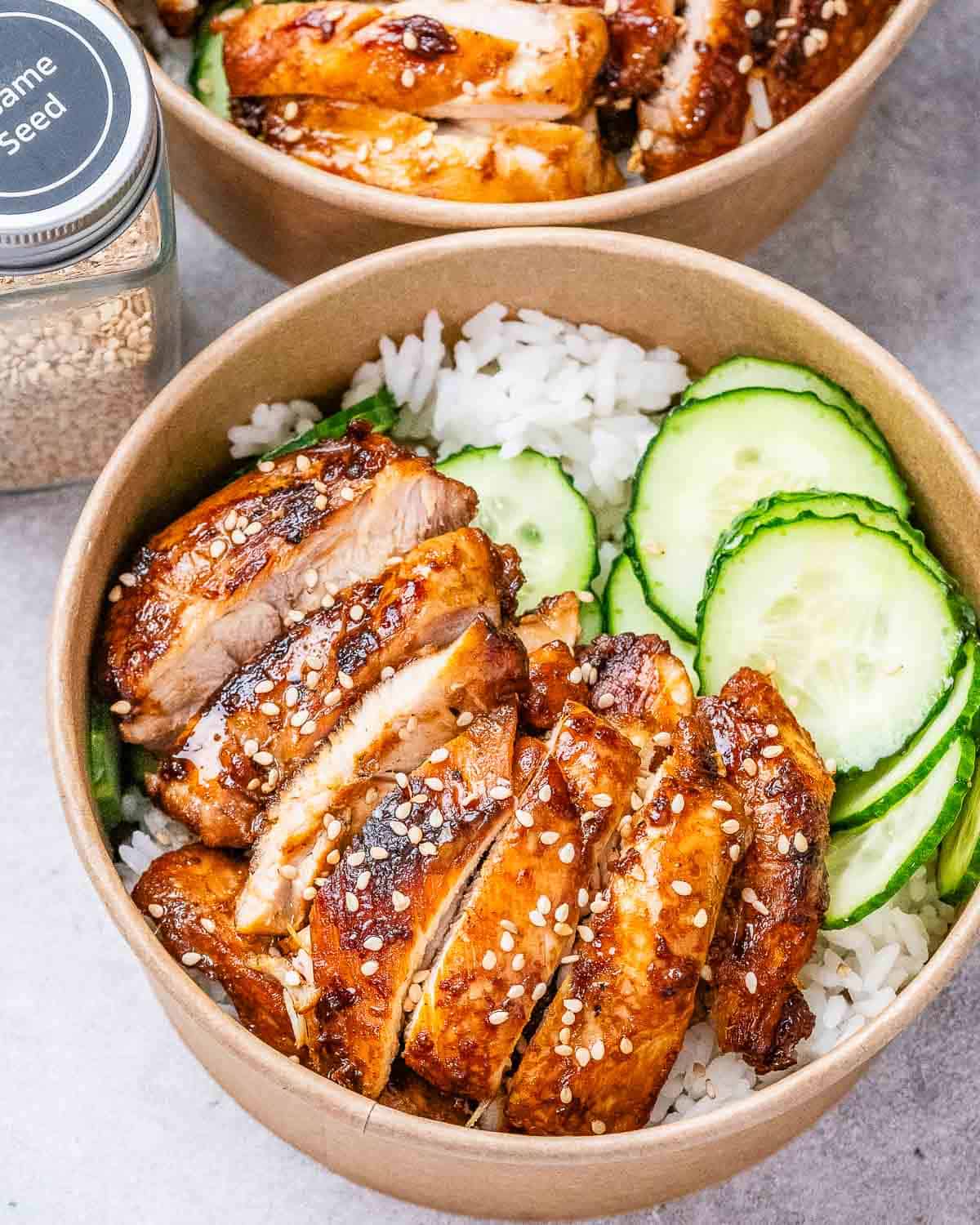 Chicken, rice, and cucumbers in a bowl.