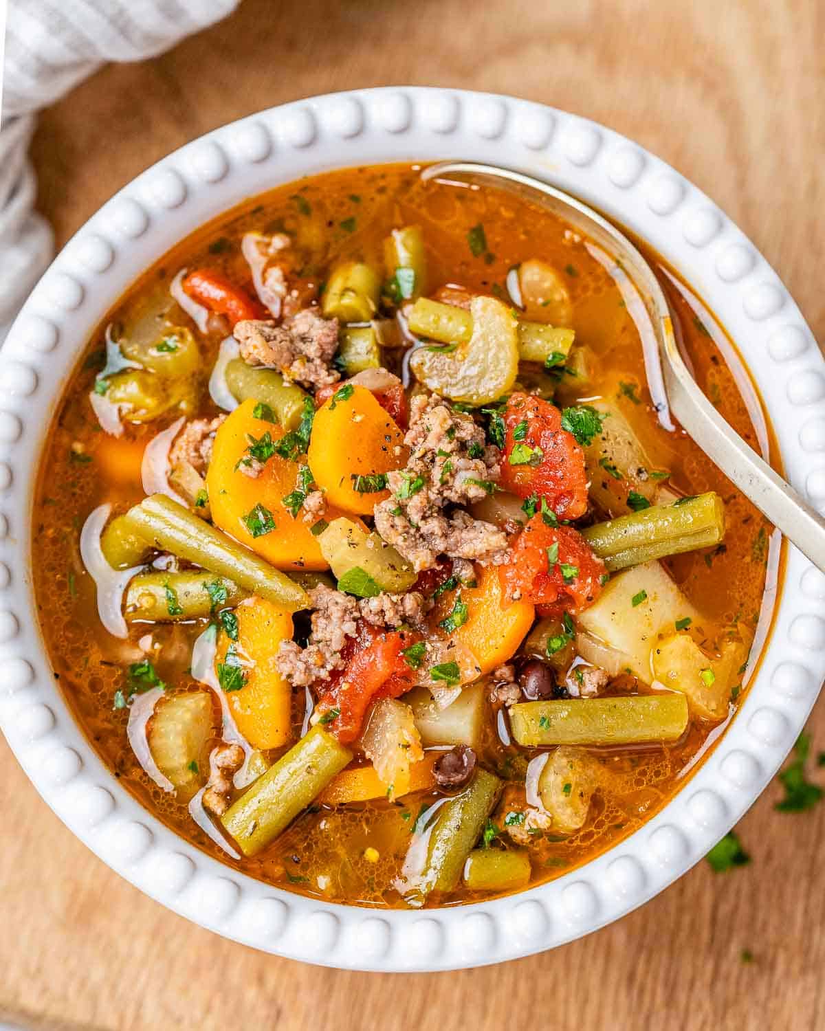 top view of cowboy soup in round white bowl with spoon