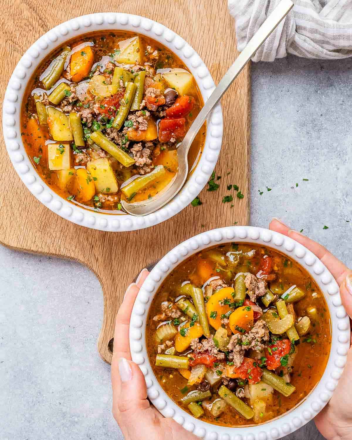 two round white bowls with cowboy soup and a spoon