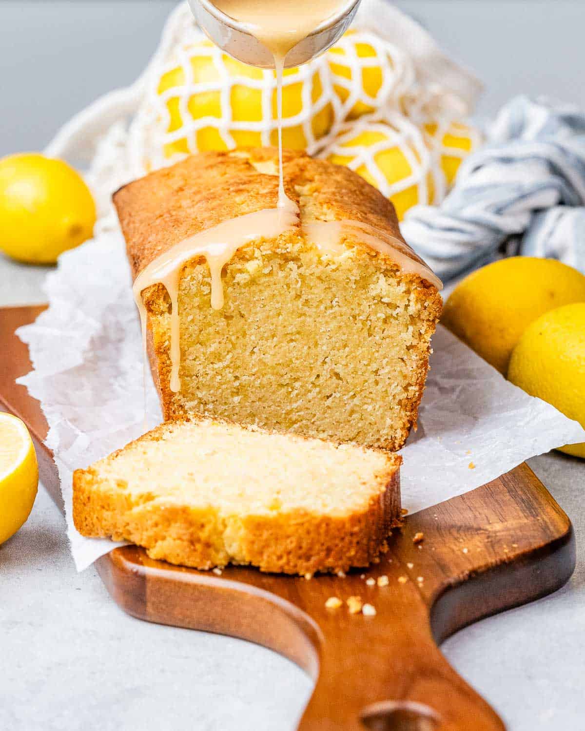 a cutting board with lemon pound cake that is partially sliced.