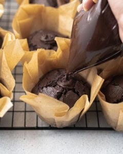 chocolate ganache being added to the middle of the muffins.