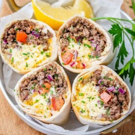 4 breakfast burrito halves in a bowl.