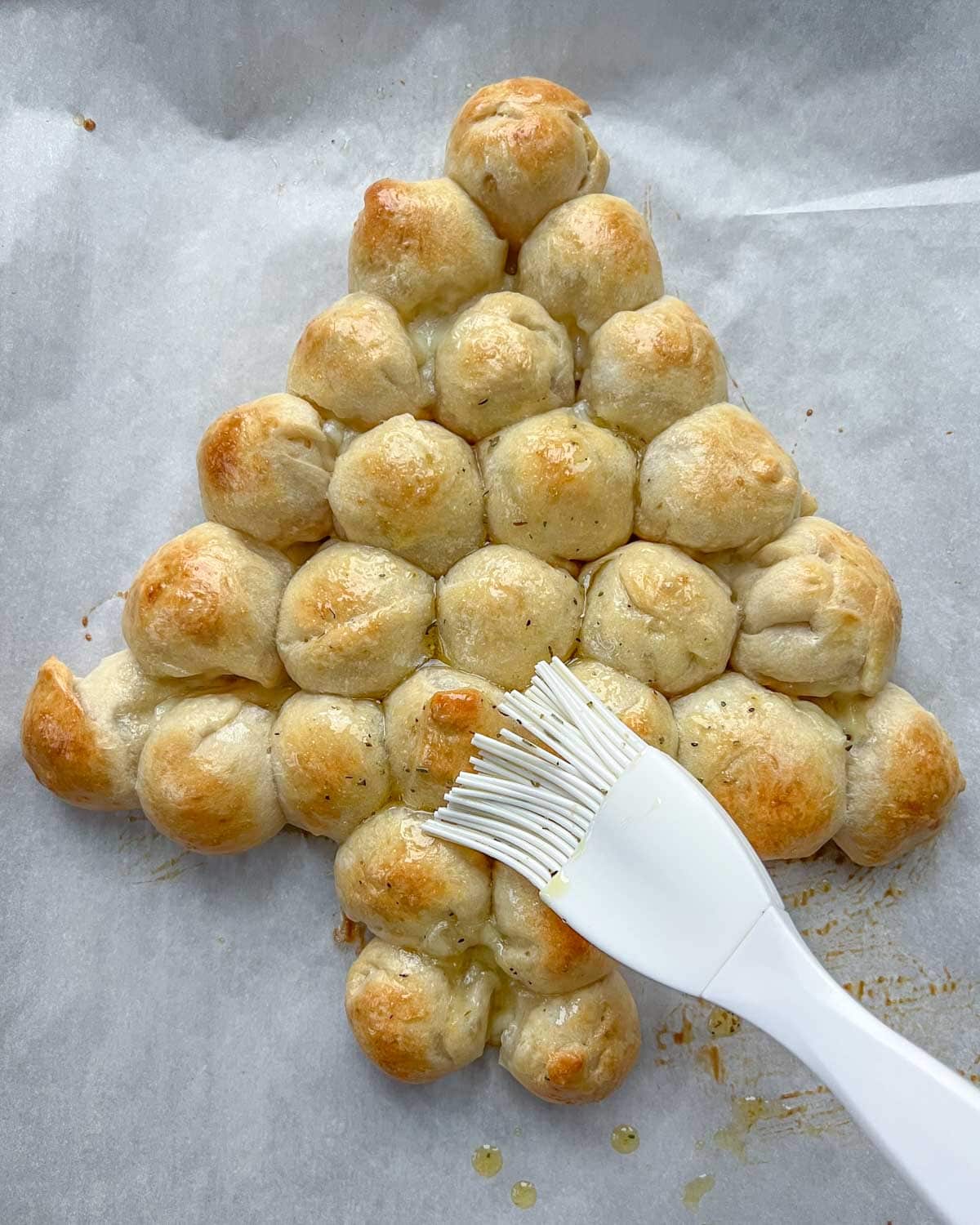 herbed oil is brushed over the baked cheeseballs.