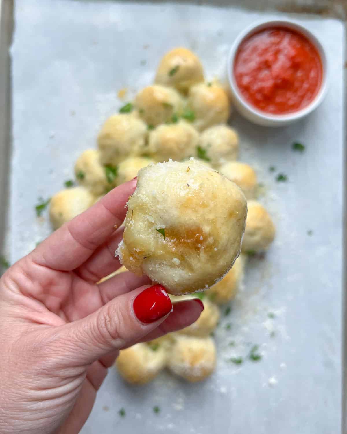 hand holding one cheese ball bread.