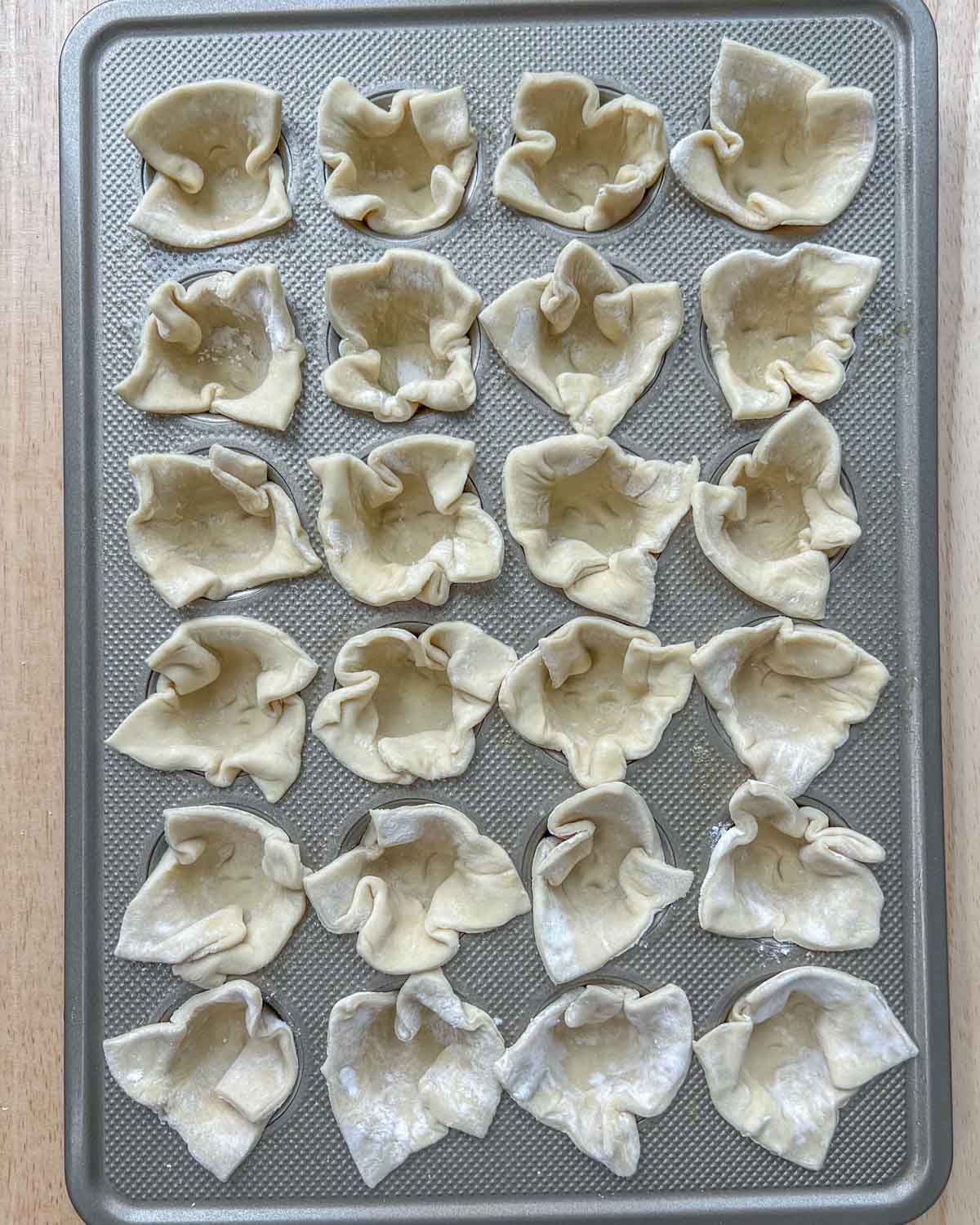 push the pastry squares added into each muffin tin.