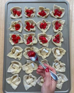 cranberry being added over each brie bite.