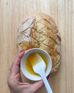 a bowl of oil over the bread and brush to rub oil on the bread.