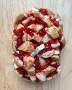 Cranberry bread is added to a sheet pan before baking.