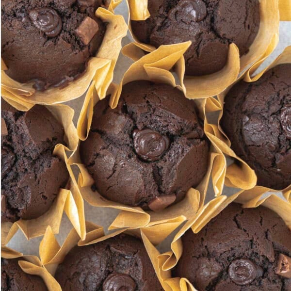 Chocolate muffins, known as Olympic village muffins, are stacked next to each other.