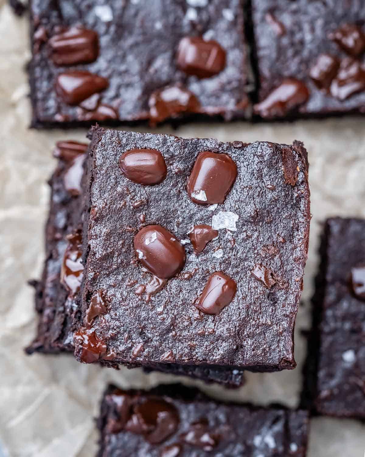 brownies stacked on each other on parchment paper.