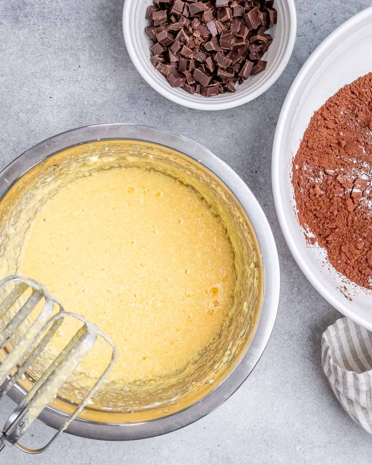 wet batter is added to a bowl and whisked, to make brownies. 