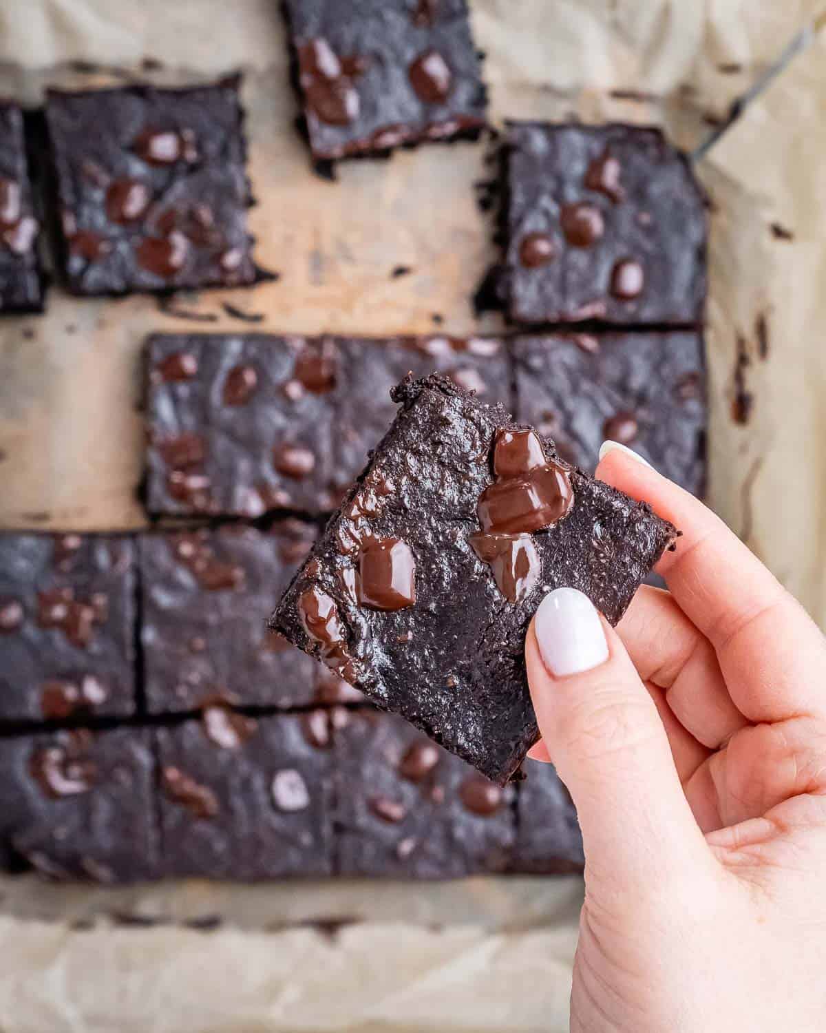 hand holding a single brownie over the brownie squares.