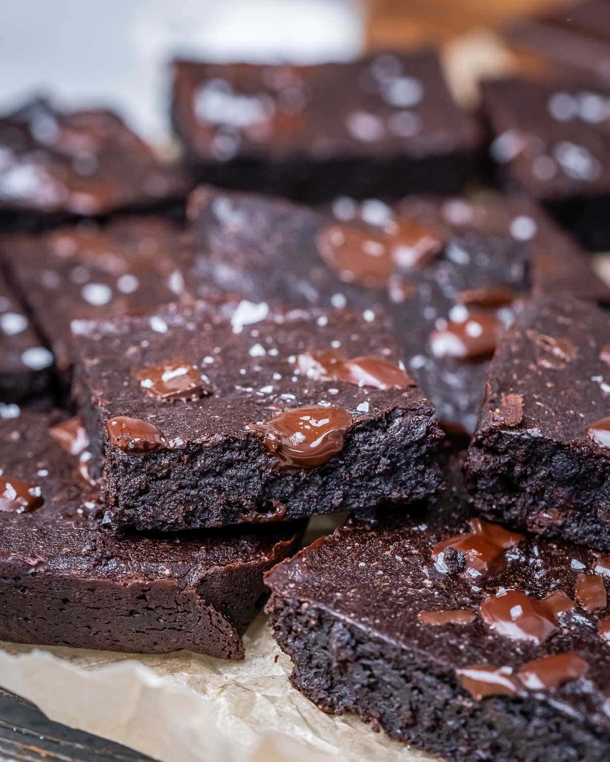 brownies stacked on each other on a parchment paper. 