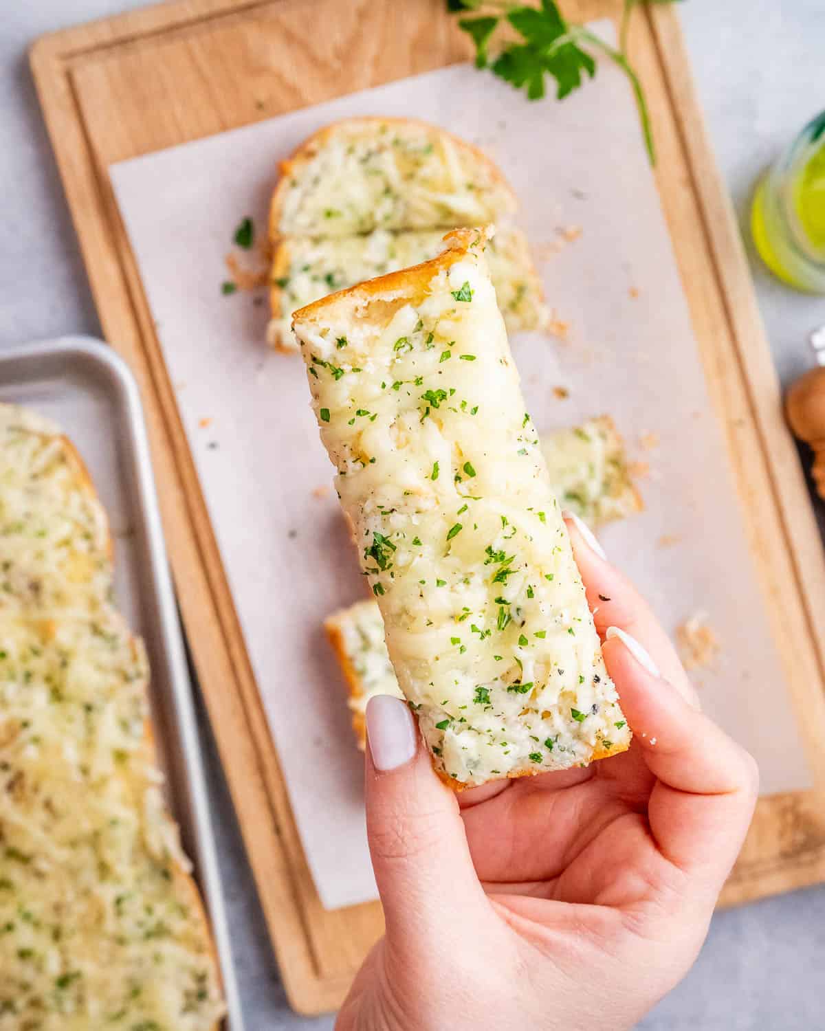 hand holding a piece of garlic bread.