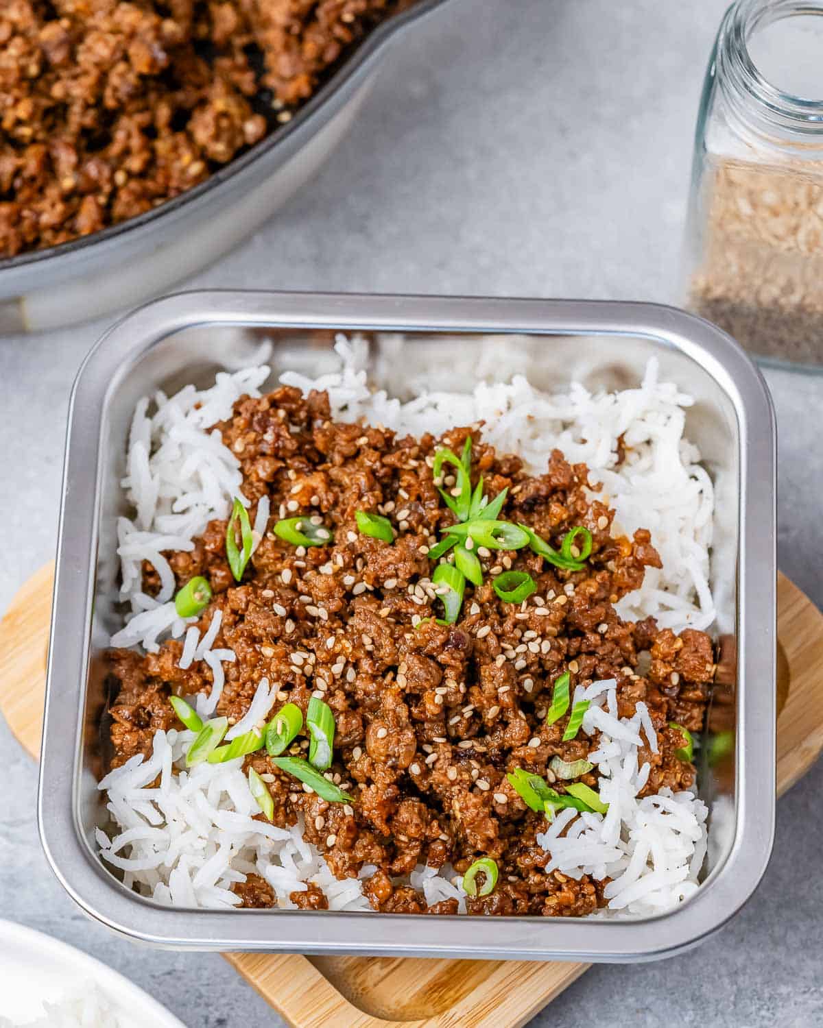 A square container filled with rice and ground beef on top.