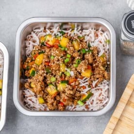 meal prep container with rice and topped with ground turkey and veggies.