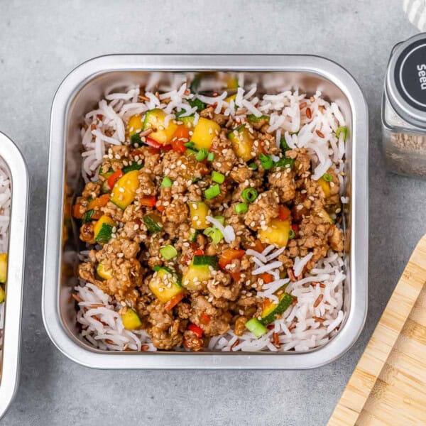 meal prep container with rice and topped with ground turkey and veggies.