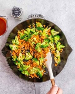Stirring vegetables in a skillet.