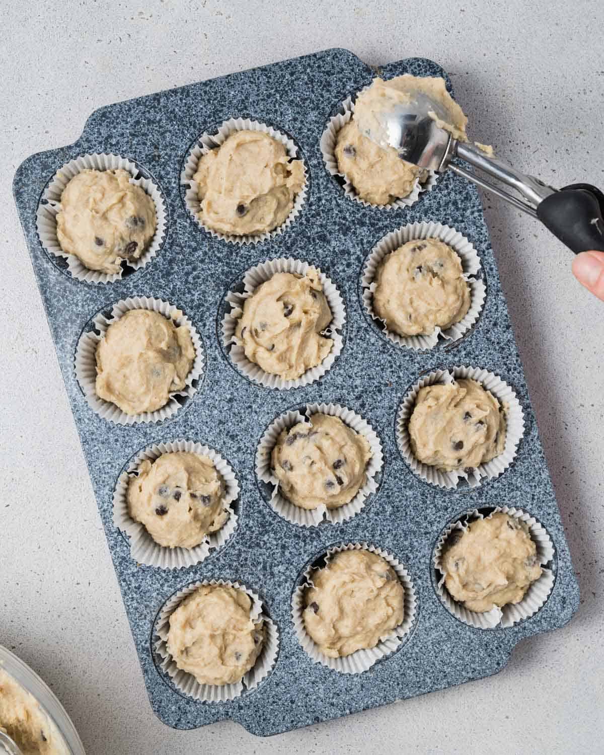 batter adding into muffin tin pan.